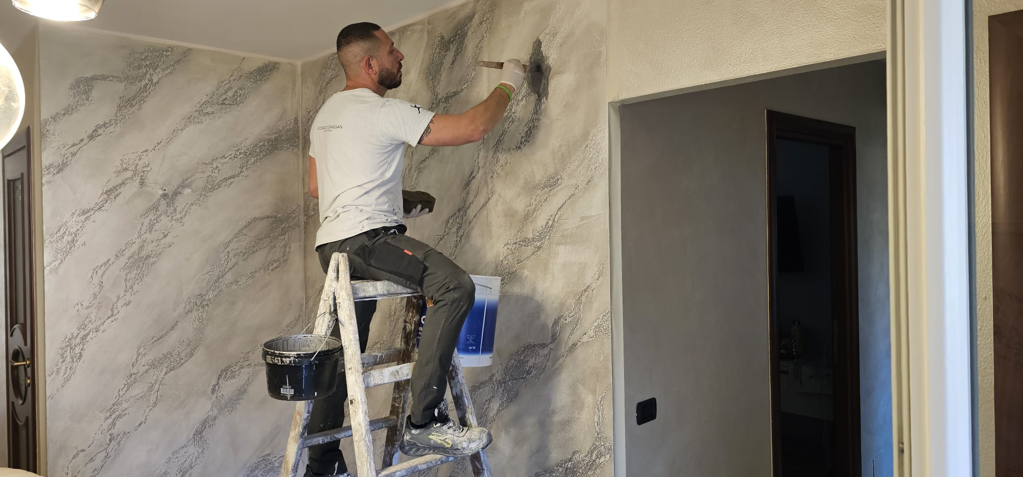 Salvatore Pollara, decoratore Shus Decorazioni, al lavoro su una finitura materica a Torino